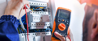 An electrician testing a fuse box