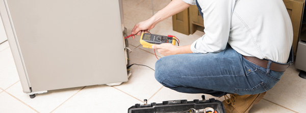 An electrician fixing a fridge